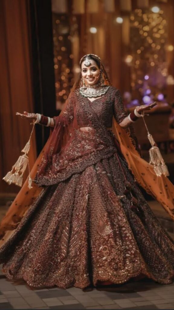 Indian bride dressed in a red and gold lehenga with traditional jewelry, exuding royal elegance on her wedding day.