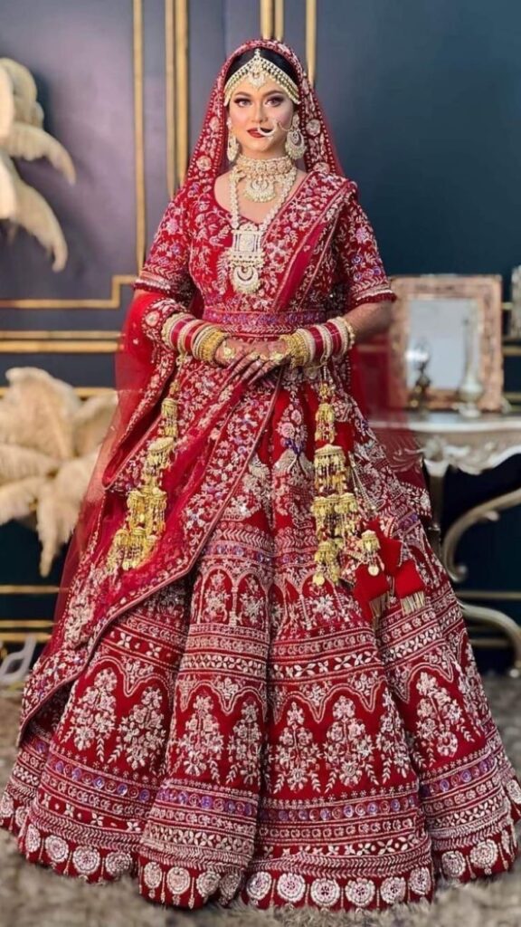 Indian bride in a luxurious red and gold lehenga with traditional jewelry, radiating grace and elegance on her wedding day.